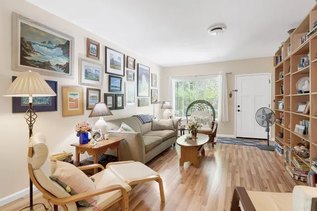 a living room with fireplace furniture and a large window