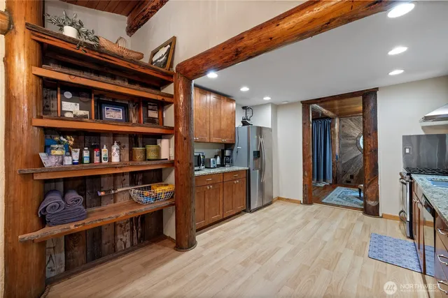 a open kitchen with stainless steel appliances granite countertop a refrigerator a stove and a wooden floors