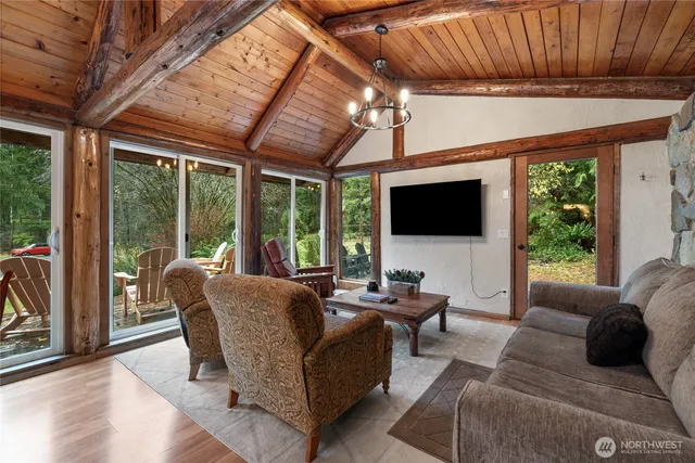 a living room with furniture a flat screen tv and a floor to ceiling window