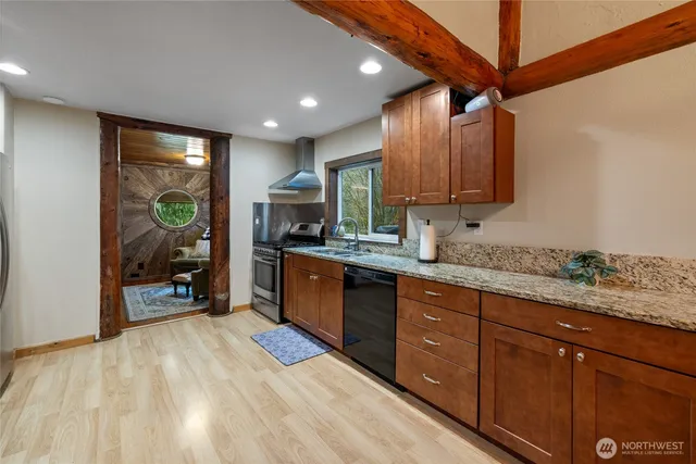 a kitchen with stainless steel appliances granite countertop wooden cabinets a sink and a stove
