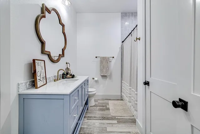 a bathroom with a sink a toilet and shower