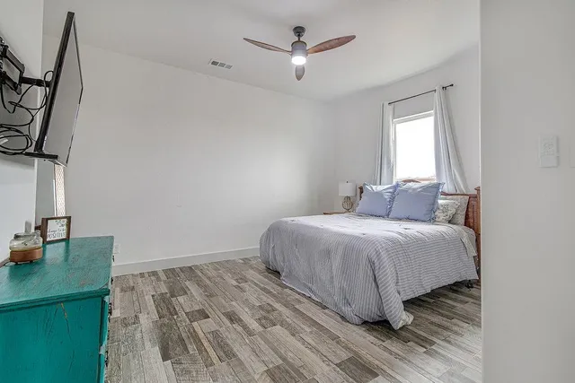a bedroom with a bed and a dresser with the outer view