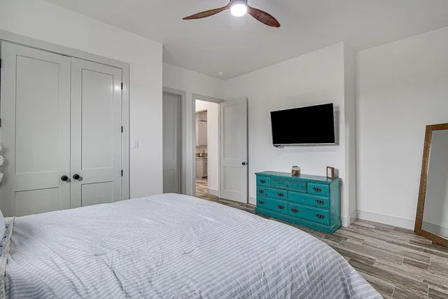 a bedroom with a bed and a flat tv screen on dresser