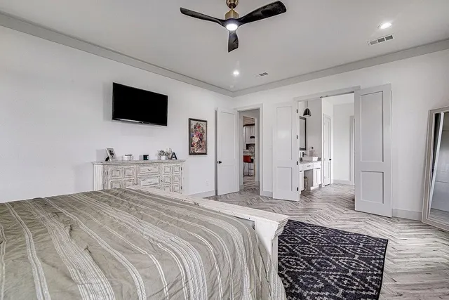 a spacious bedroom with a bed and a flat screen tv