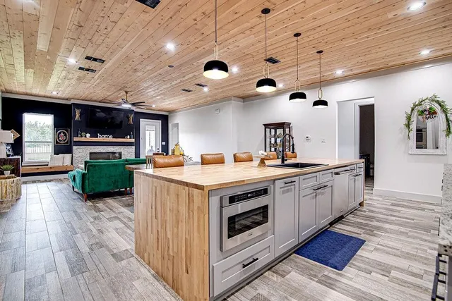 a large kitchen with stainless steel appliances granite countertop a large center island and a wooden floors