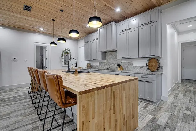 a kitchen with stainless steel appliances granite countertop a sink a stove and a wooden floors