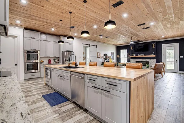 a kitchen with stainless steel appliances kitchen island granite countertop a sink and cabinets
