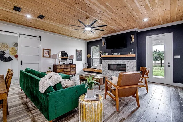 a living room with furniture a flat screen tv and a fireplace