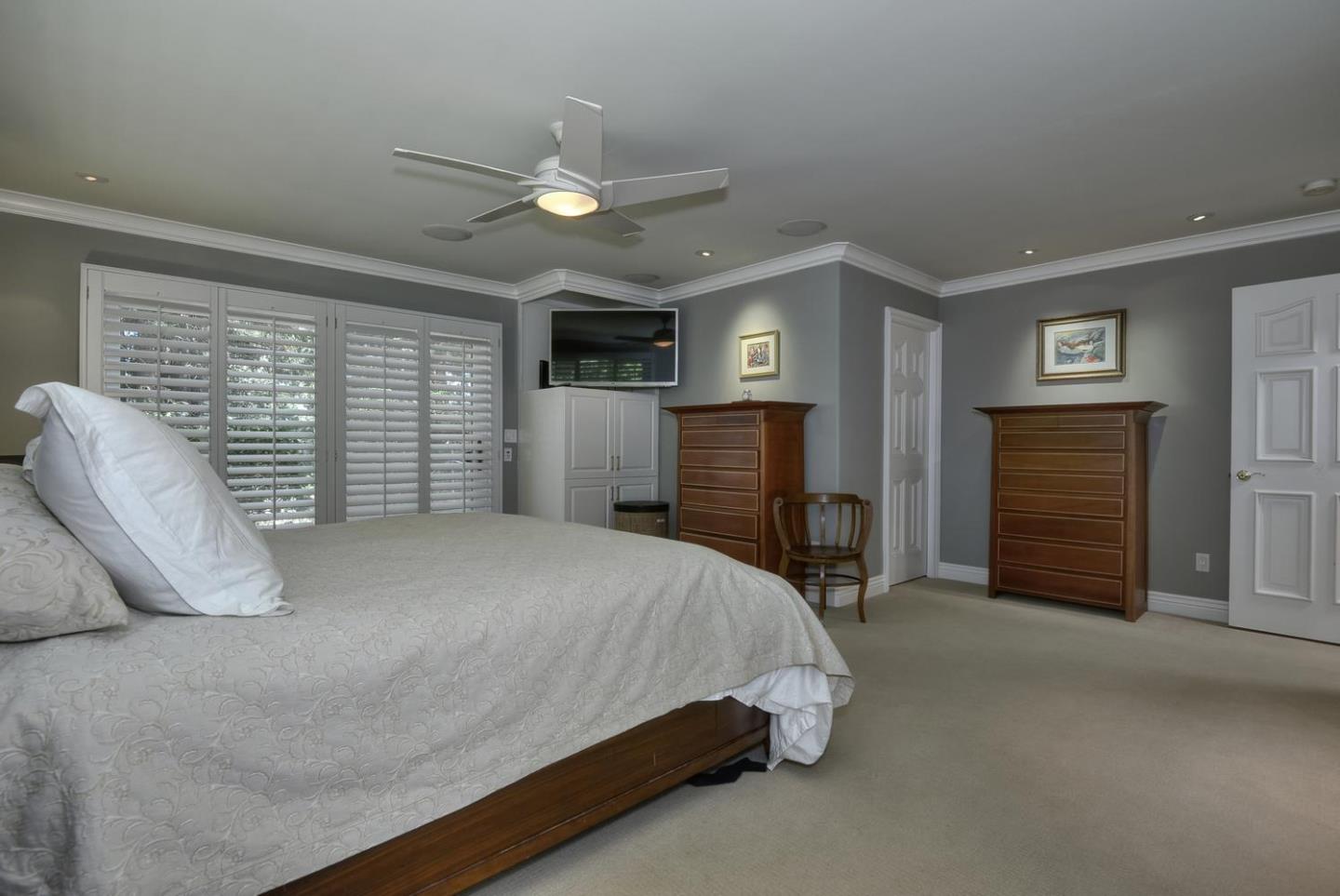815 Patrol Road Woodside, CA 94062 - Photo 9 of 16 a spacious bedroom with a bed and a chandelier