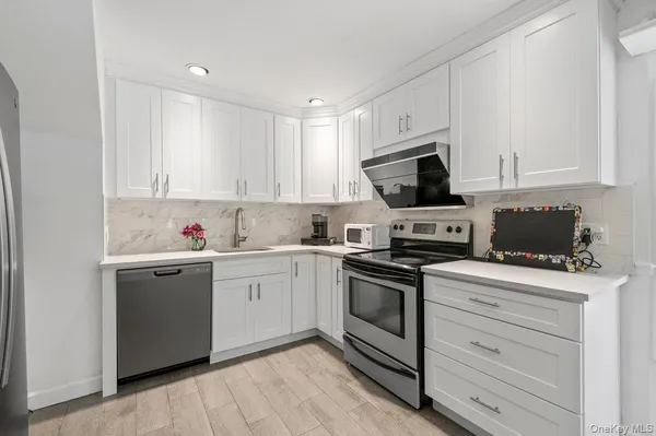 a kitchen with granite countertop white cabinets and white appliances