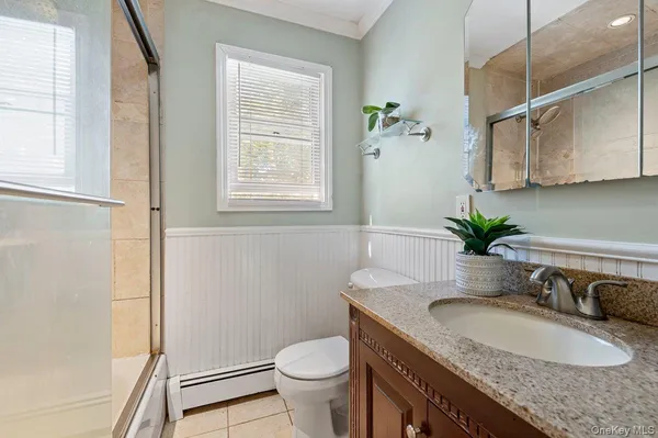 a bathroom with a granite countertop sink a toilet and a mirror