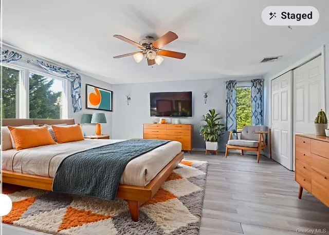 a bedroom with a large bed and a flat tv screen