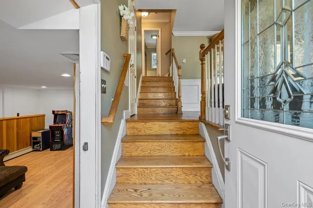 a view of staircase with lots of frames on wall and a large window