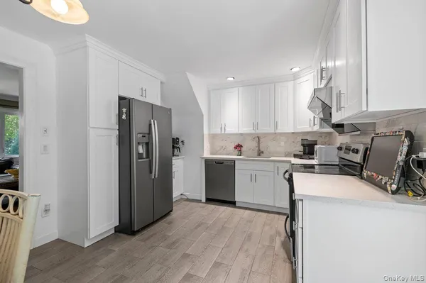 a kitchen with a refrigerator sink and cabinets