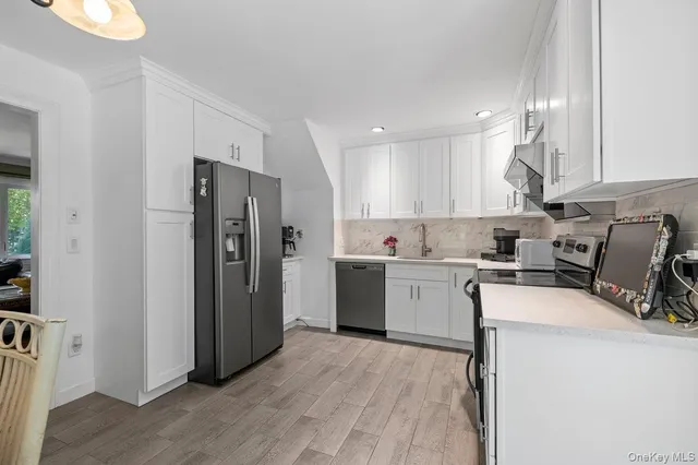 a kitchen with a refrigerator sink and cabinets