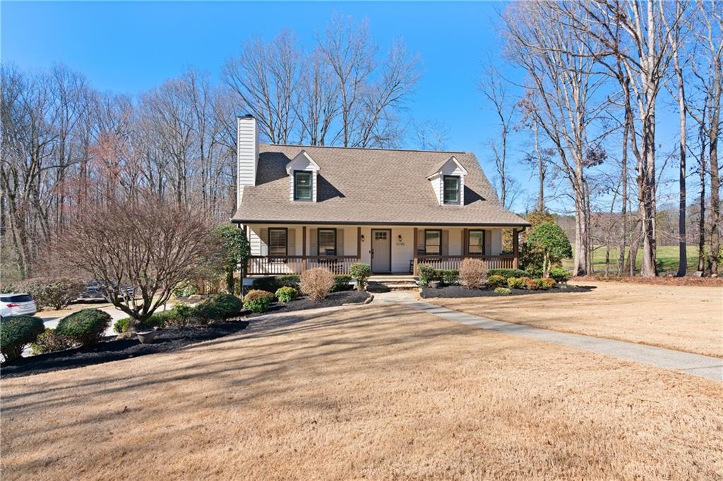 a front view of a house with a yard and a car parked in front of it