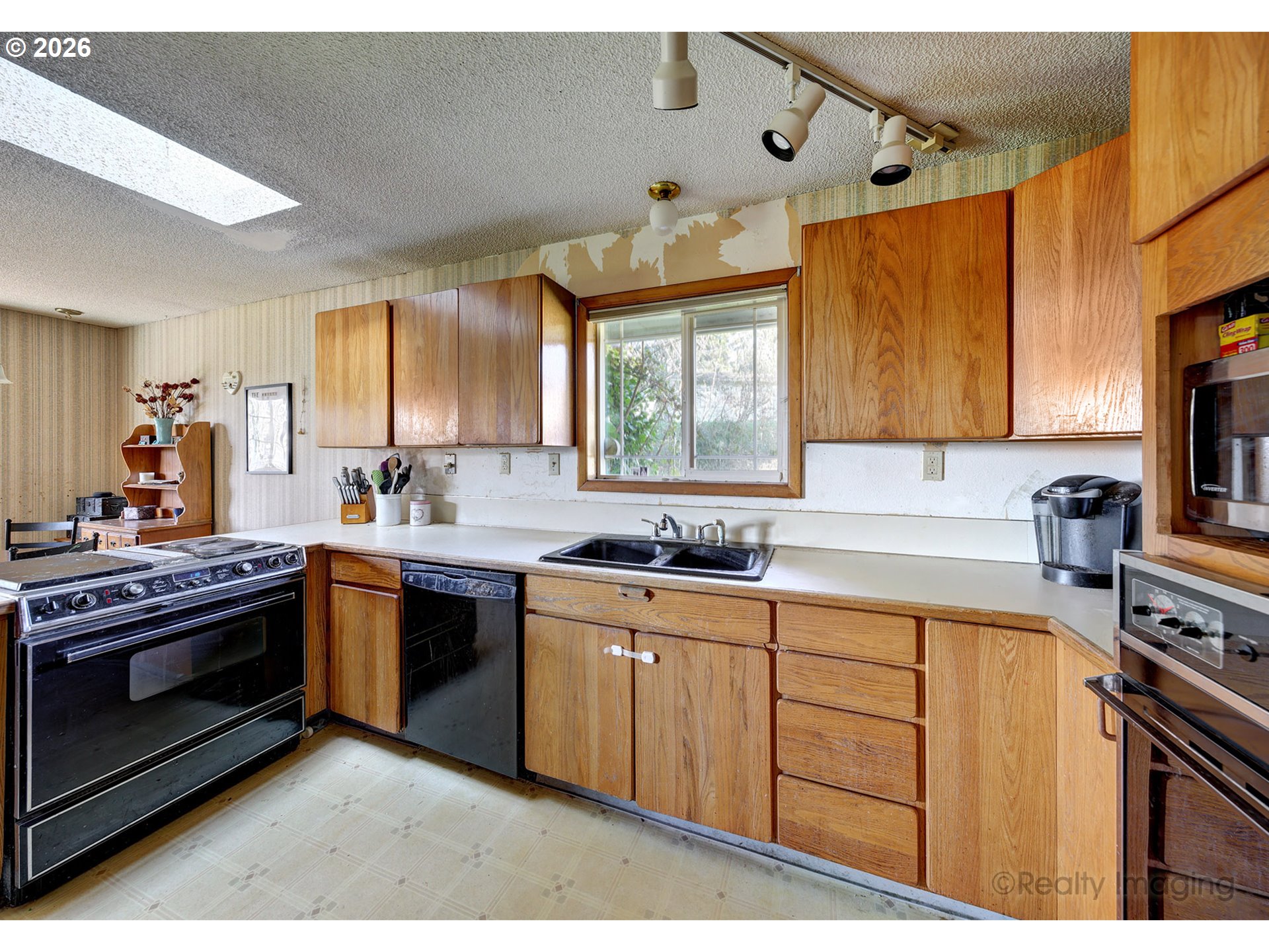 1703 Allen Street Kelso, WA 98626 - Photo 4 of 23 a kitchen with stainless steel appliances granite countertop a sink a stove a refrigerator cabinets and a window