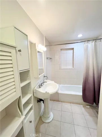 a bathroom with a sink a toilet a mirror and shower