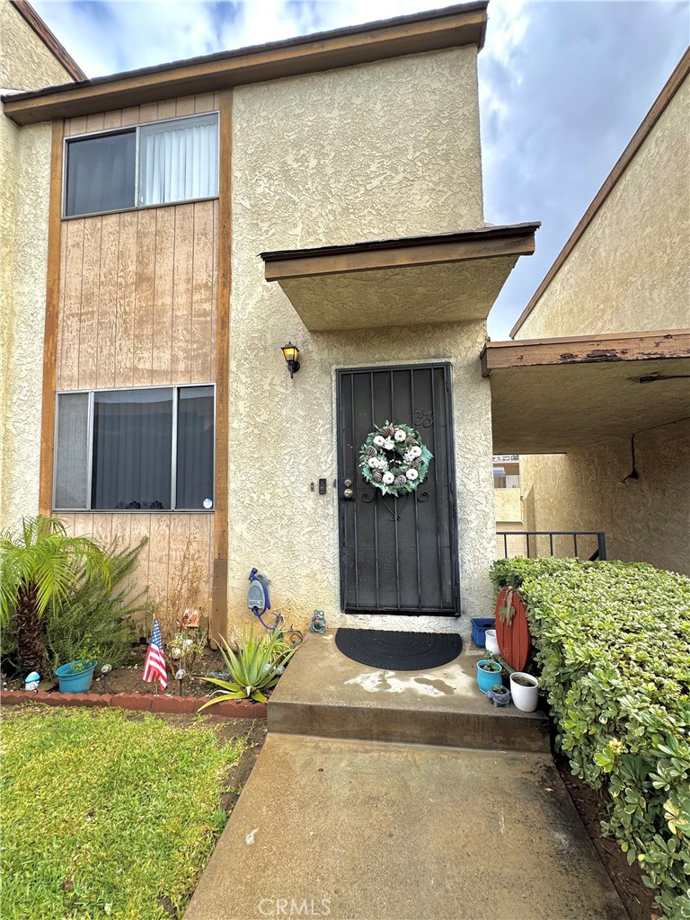 a front view of a house with a yard and potted plants