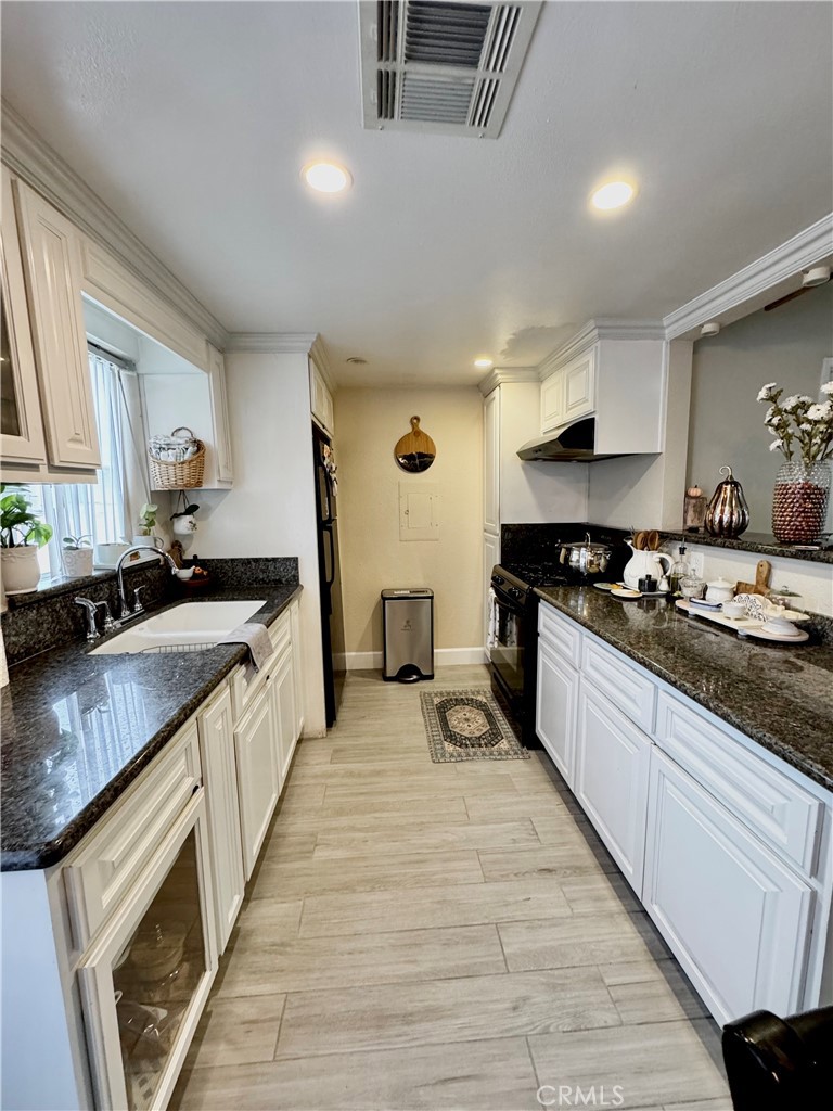 13450 Meyer Road, Unit 33 Whittier, CA 90605 - Photo 4 of 10 a large kitchen with stainless steel appliances granite countertop a lot of counter space and wooden floors