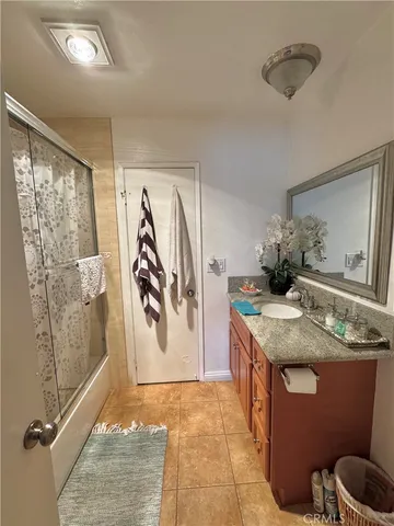 a bathroom with a granite countertop sink a toilet and shower