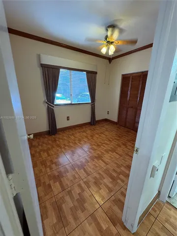 a view of an empty room with a chandelier fan