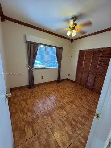 a view of a hallway with wooden floor and a bathroom