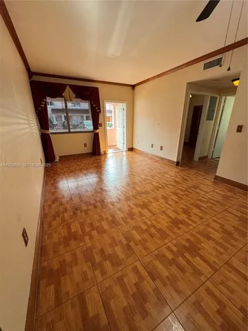 a view of an empty room with wooden floor and entryway