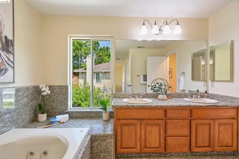 a bathroom with a granite countertop sink a toilet and a shower