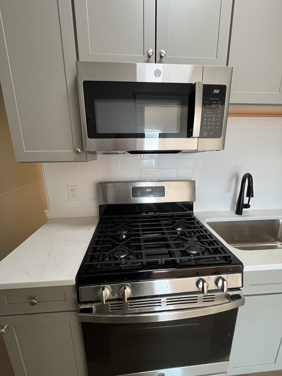 108 Bristol Road, Unit 1 Somerville, MA 02144 - Photo 3 of 24 a kitchen with microwave stove and cabinets