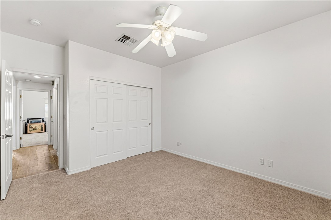 9332 Branded Road Kingman, AZ 86401 - Photo 32 of 44 an empty room with closet and a ceiling fan