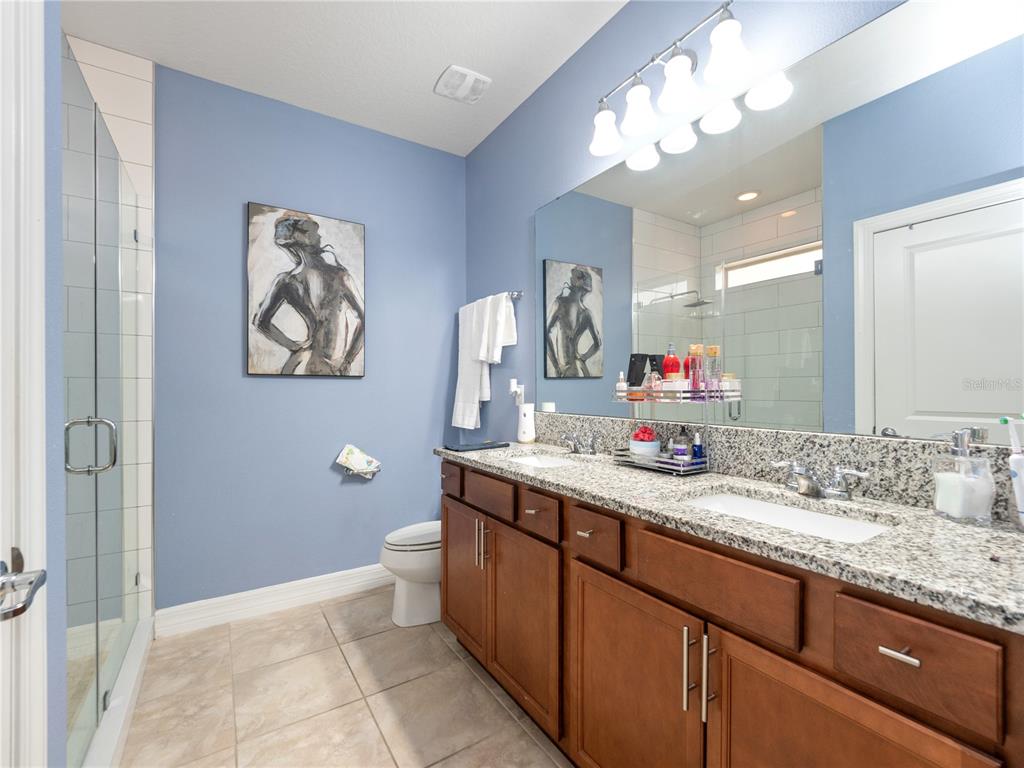 3570 Southern Cross Loop Kissimmee, FL 34744 - Photo 18 of 36 a bathroom with a granite countertop sink a toilet and a mirror