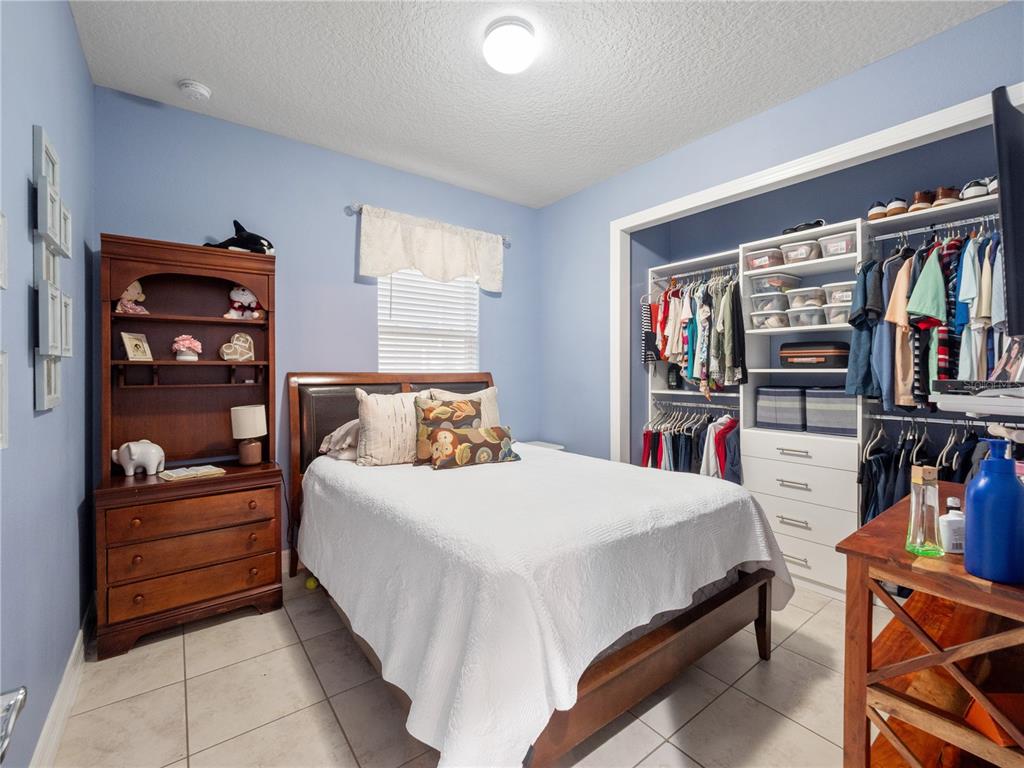 3570 Southern Cross Loop Kissimmee, FL 34744 - Photo 19 of 36 a bedroom with a bed and a book shelf