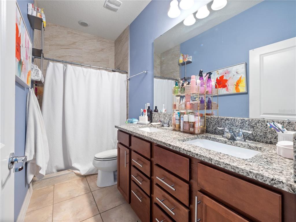 3570 Southern Cross Loop Kissimmee, FL 34744 - Photo 21 of 36 a bathroom with a granite countertop sink and a mirror