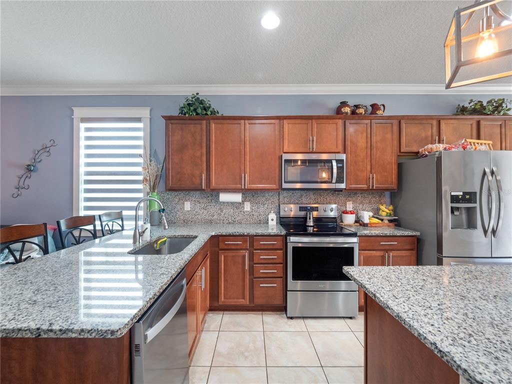 3570 Southern Cross Loop Kissimmee, FL 34744 - Photo 5 of 36 a kitchen with stainless steel appliances granite countertop a sink stove and refrigerator