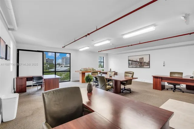a living room with furniture kitchen view and a large window