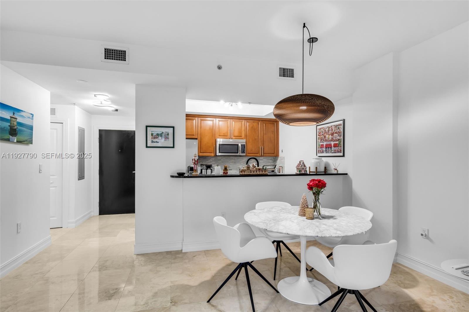 1650 Galiano Street, Unit 311 Coral Gables, FL 33134 - Photo 10 of 32 a kitchen with stainless steel appliances kitchen island granite countertop a table and chairs in it