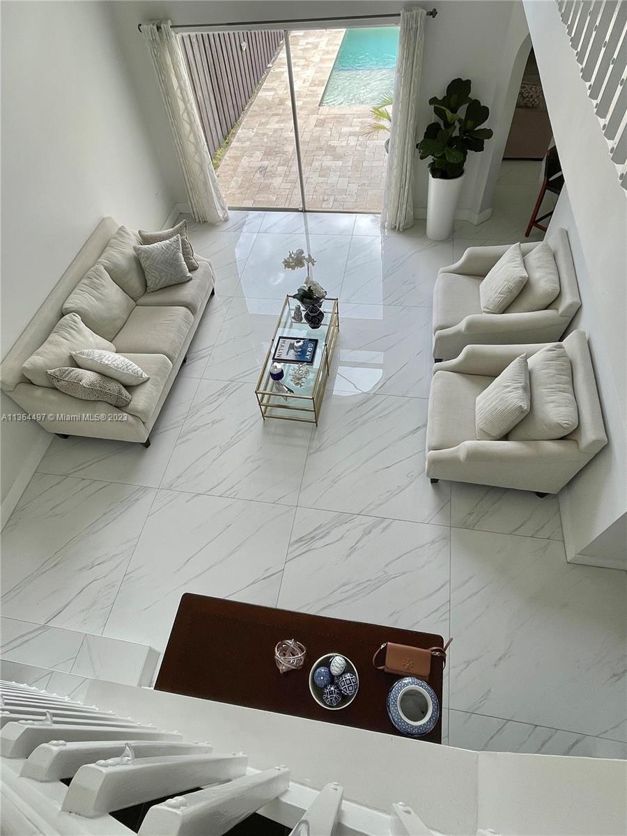 15542 Southwest 148th Terrace Miami, FL 33196 - Photo 21 of 38 a living room with furniture and a floor to ceiling window