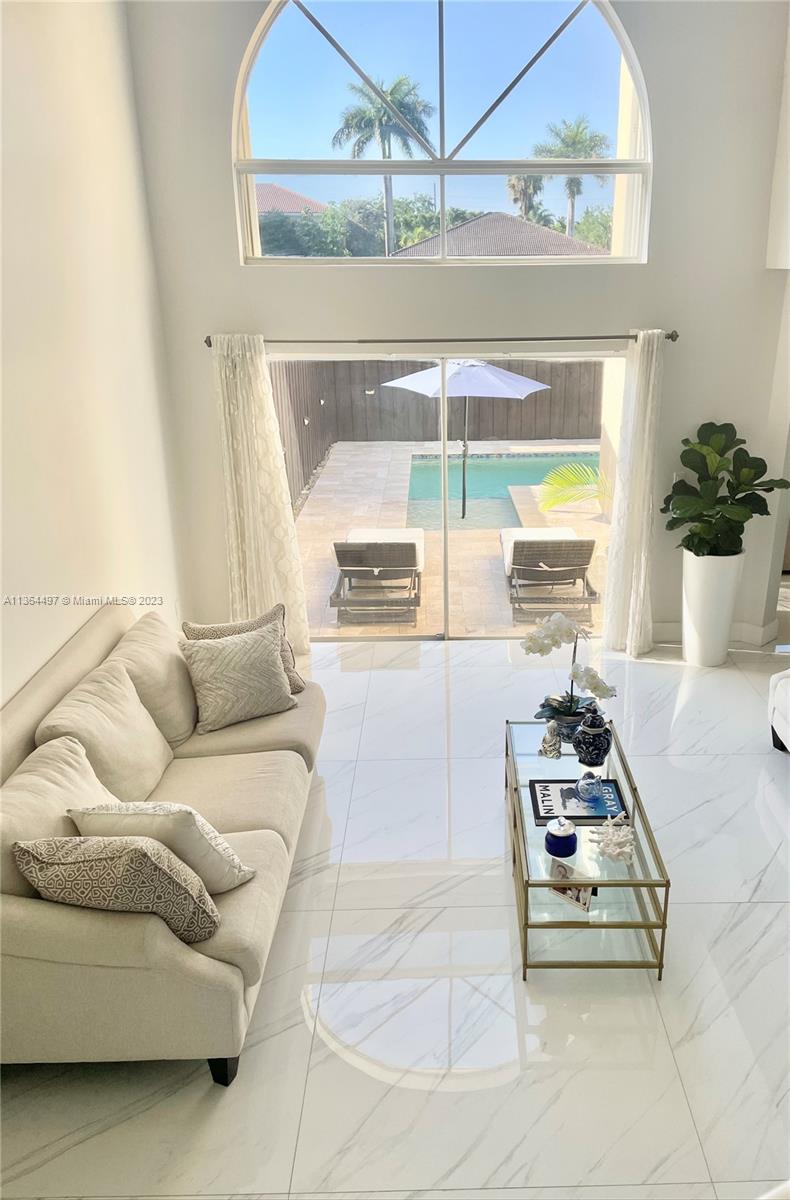 15542 Southwest 148th Terrace Miami, FL 33196 - Photo 22 of 38 a living room with furniture and a floor to ceiling window