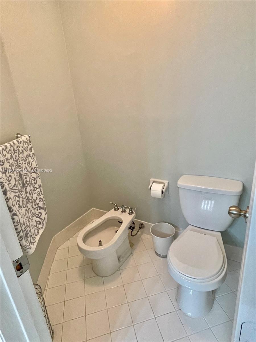 15542 Southwest 148th Terrace Miami, FL 33196 - Photo 30 of 38 a white toilet sitting next to a white sink and vanity