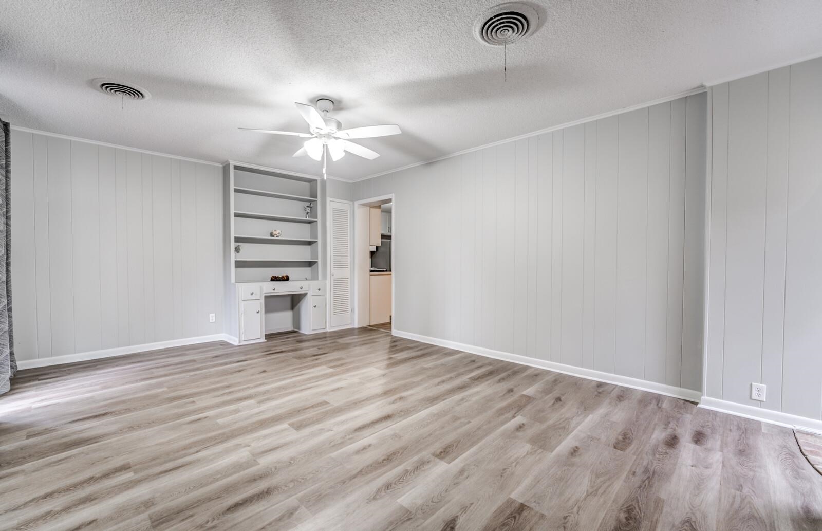 512 Fleda Road Memphis, TN 38120 - Photo 12 of 26 an empty room with wooden floor chandelier fan and windows