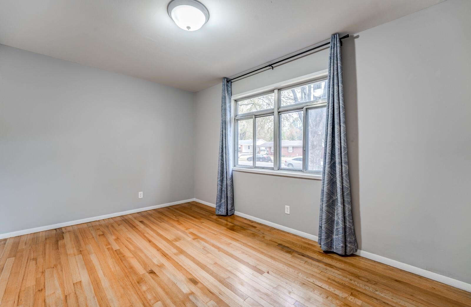 512 Fleda Road Memphis, TN 38120 - Photo 18 of 26 an empty room with wooden floor and windows