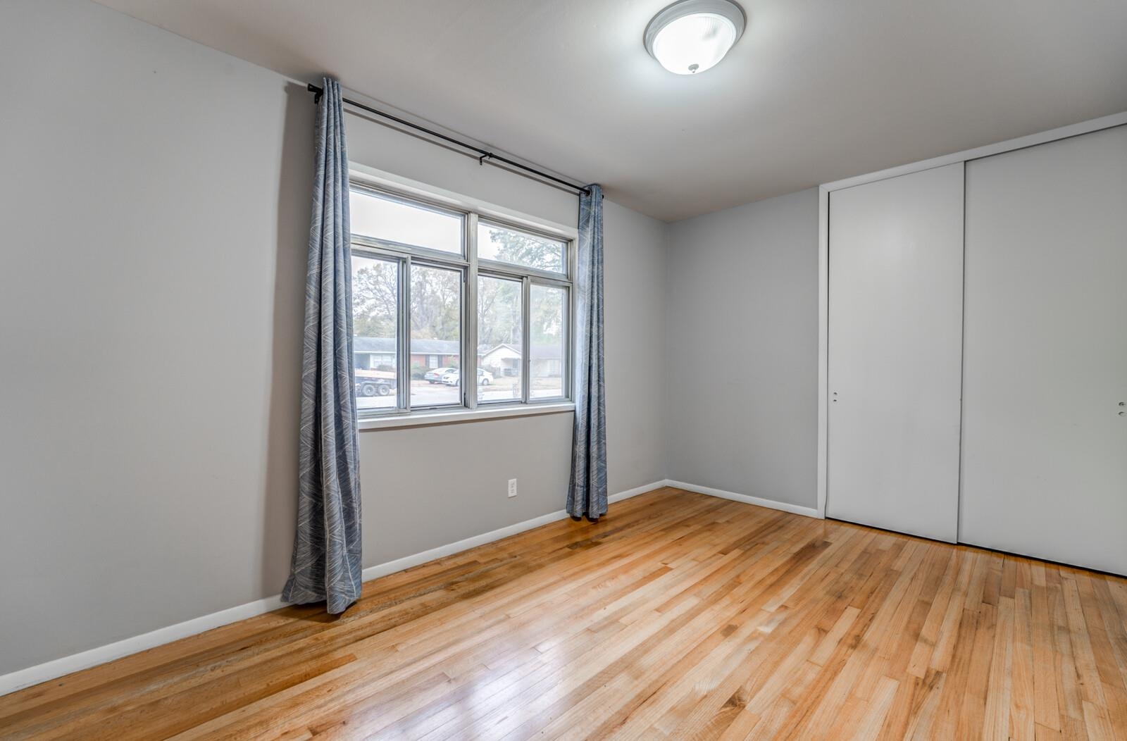 512 Fleda Road Memphis, TN 38120 - Photo 19 of 26 an empty room with wooden floor and windows