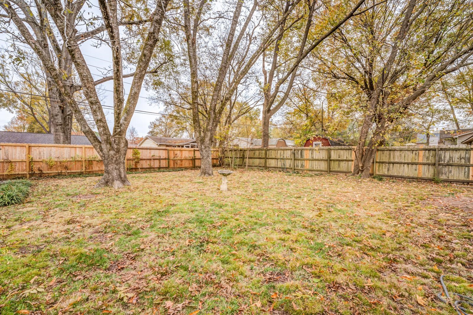 512 Fleda Road Memphis, TN 38120 - Photo 25 of 26 a view of backyard with wooden fence and large trees
