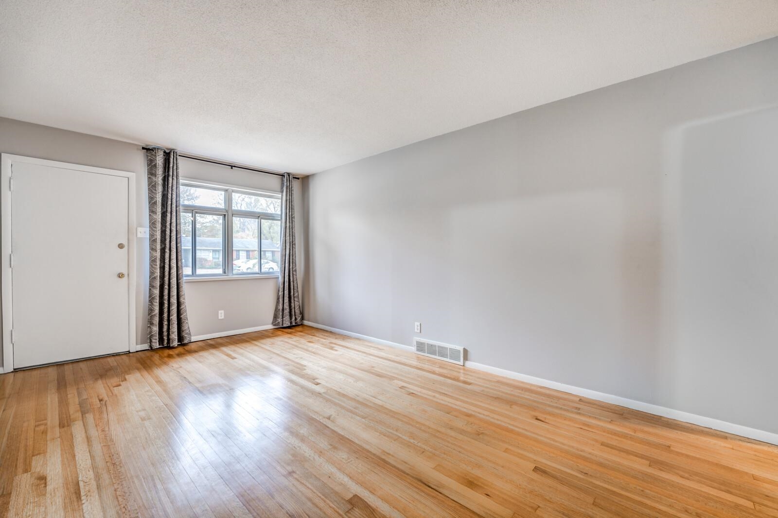 512 Fleda Road Memphis, TN 38120 - Photo 5 of 26 a view of an empty room with wooden floor and a window