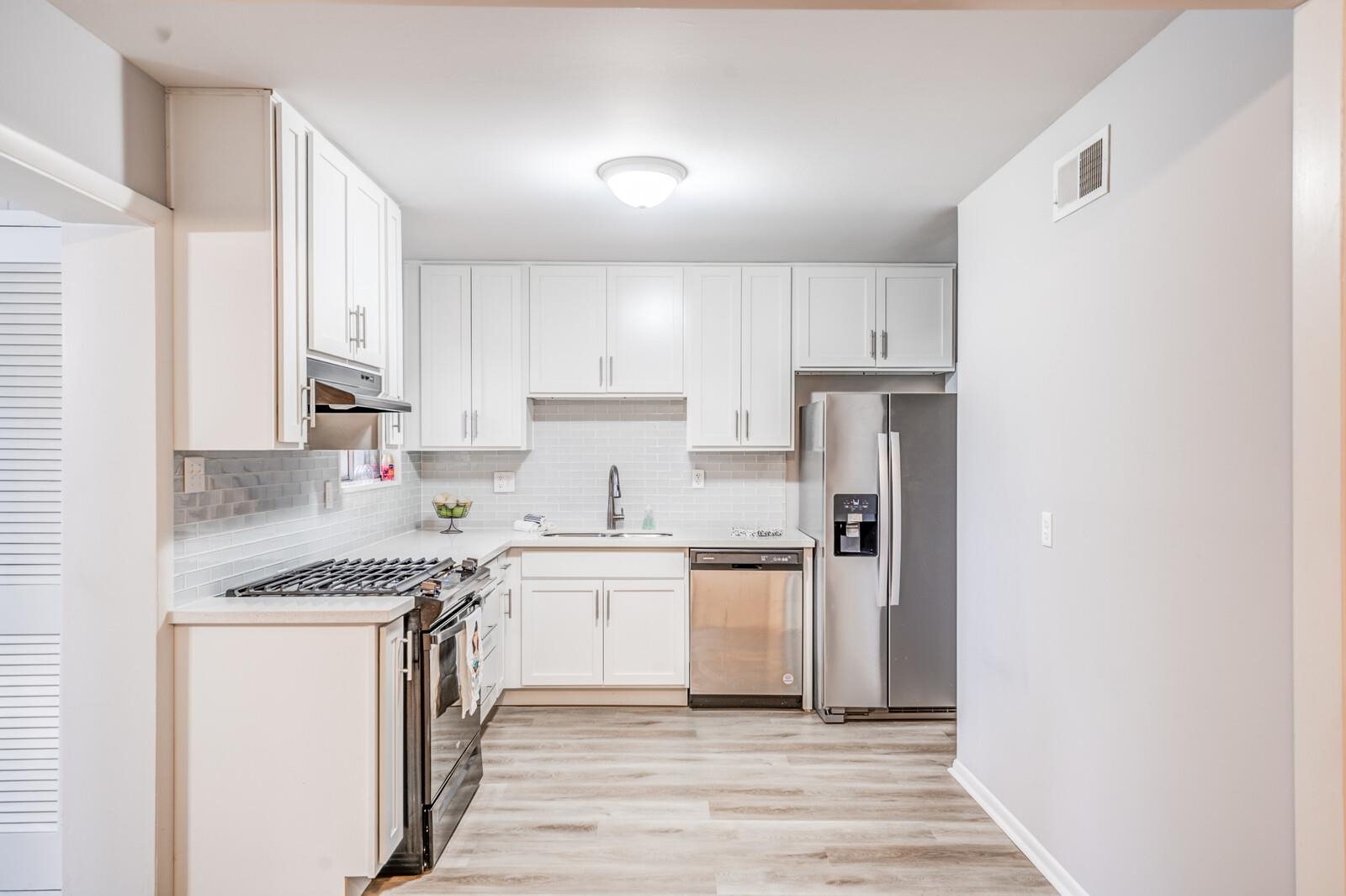 512 Fleda Road Memphis, TN 38120 - Photo 8 of 26 a kitchen with cabinets appliances a sink and a counter top space