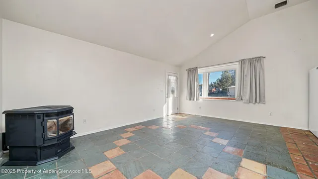 a kitchen with granite countertop a refrigerator a sink and white cabinets