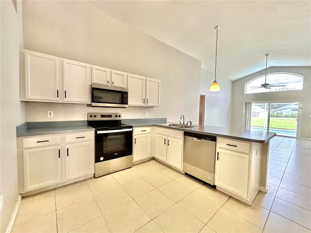 a kitchen with stainless steel appliances granite countertop a stove a sink and a microwave
