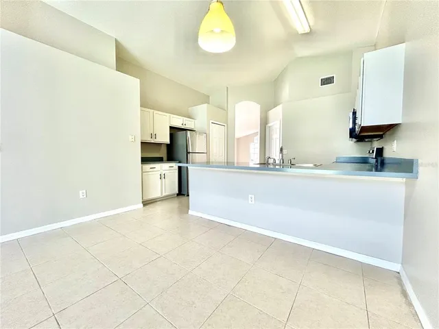 a large white kitchen with a sink and dishwasher a stove top oven with wooden floor