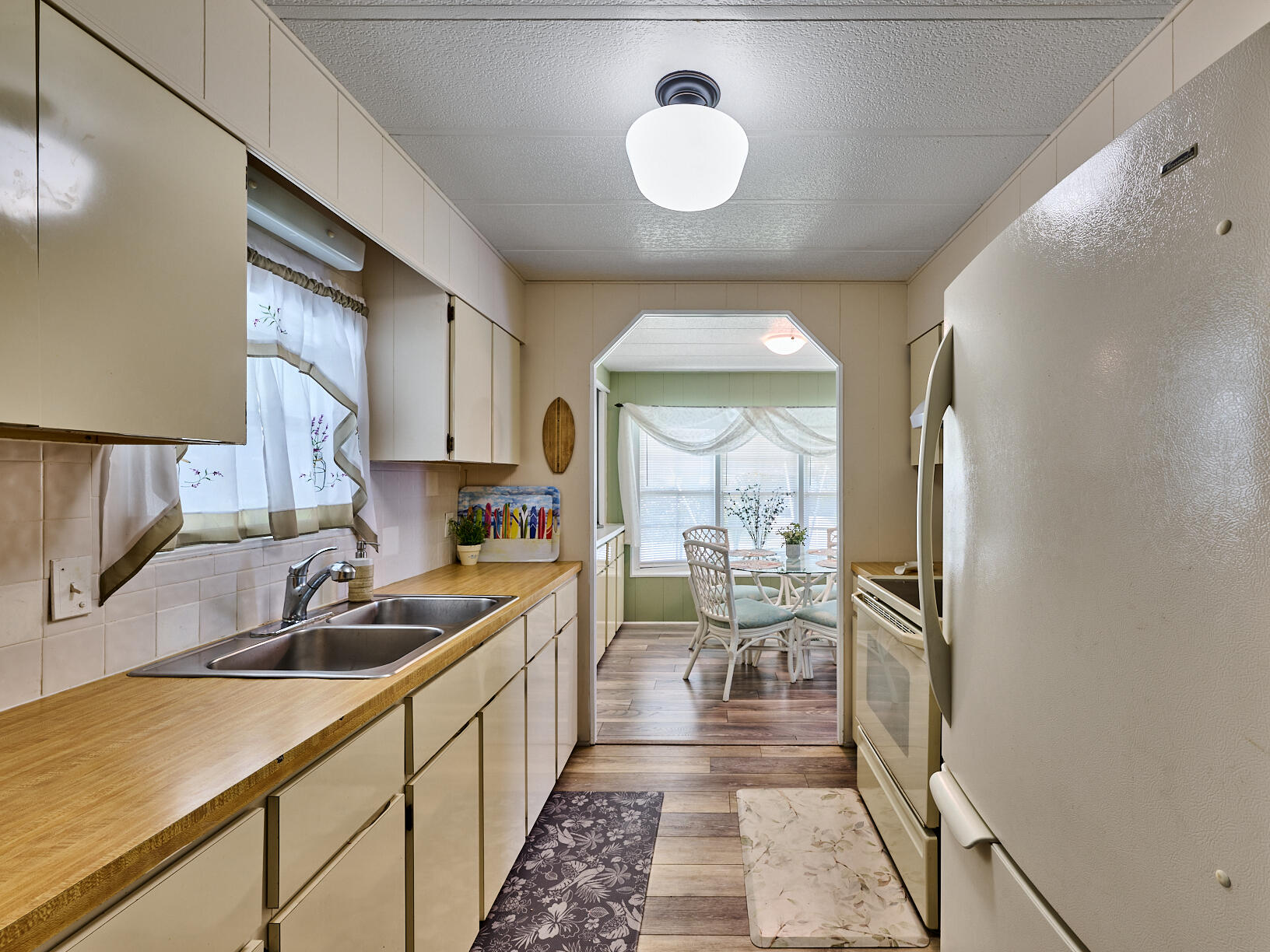 6977 Southeast Delegate Street Hobe Sound, FL 33455 - Photo 15 of 60 a kitchen with a sink stainless steel appliances cabinets and a counter top space
